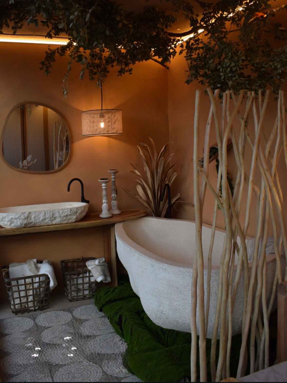 baño wabi-sabi con bañera de piedra, lavabo esculpido y mobiliario de madera en suite de diseño en Burgos