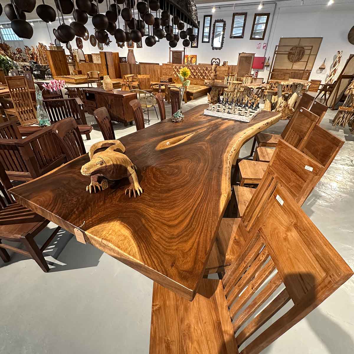 mesa de madera maciza con canto natural y banco a juego en exposicion de mobiliario de alta gama